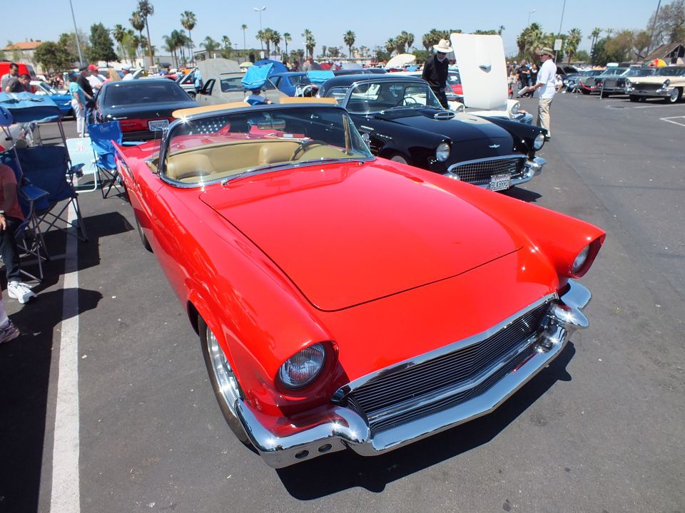 Red Ford Thunderbird roadster with tan interior at outdoor car show