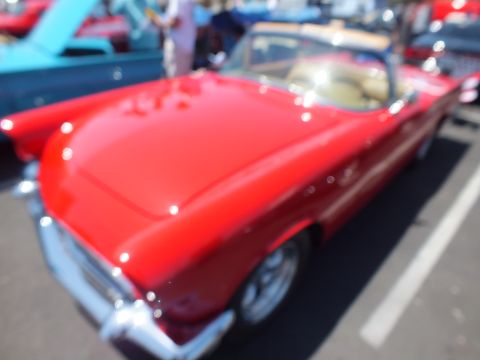 Slightly blurred red Ford Thunderbird convertible with tan interior