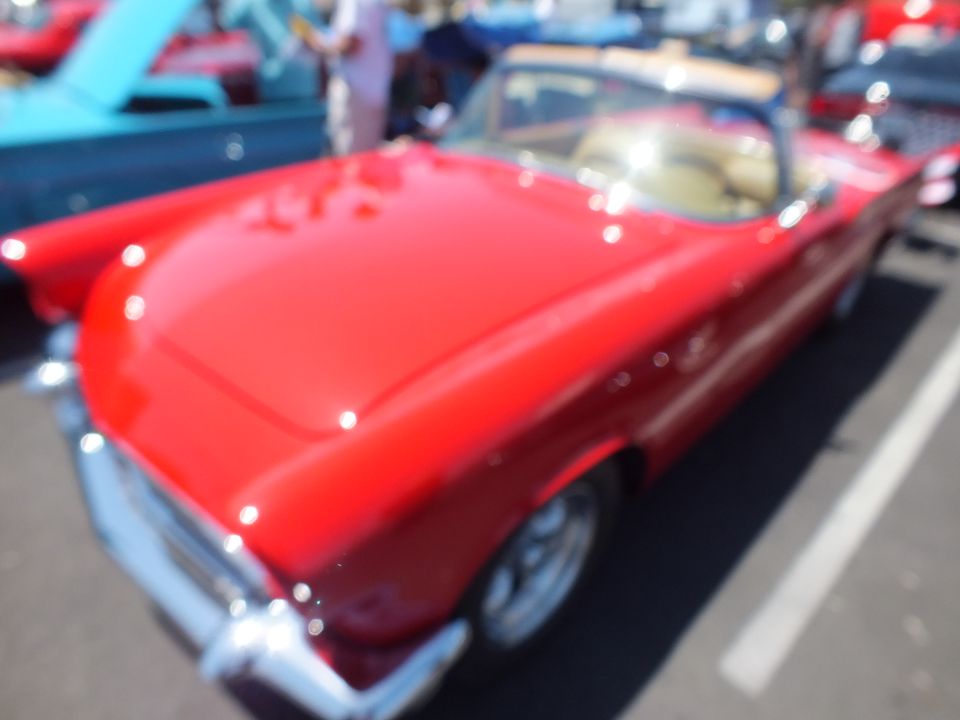 Slightly blurred red Ford Thunderbird convertible with tan interior