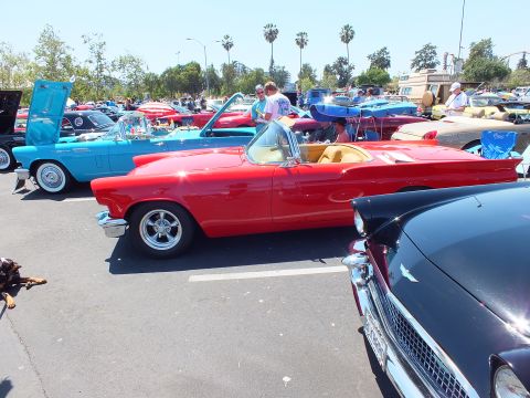 Red Ford Thunderbird convertible profile with five-spoke wheels at show