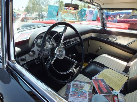 Interior of classic Ford Thunderbird with steering wheel and white seats