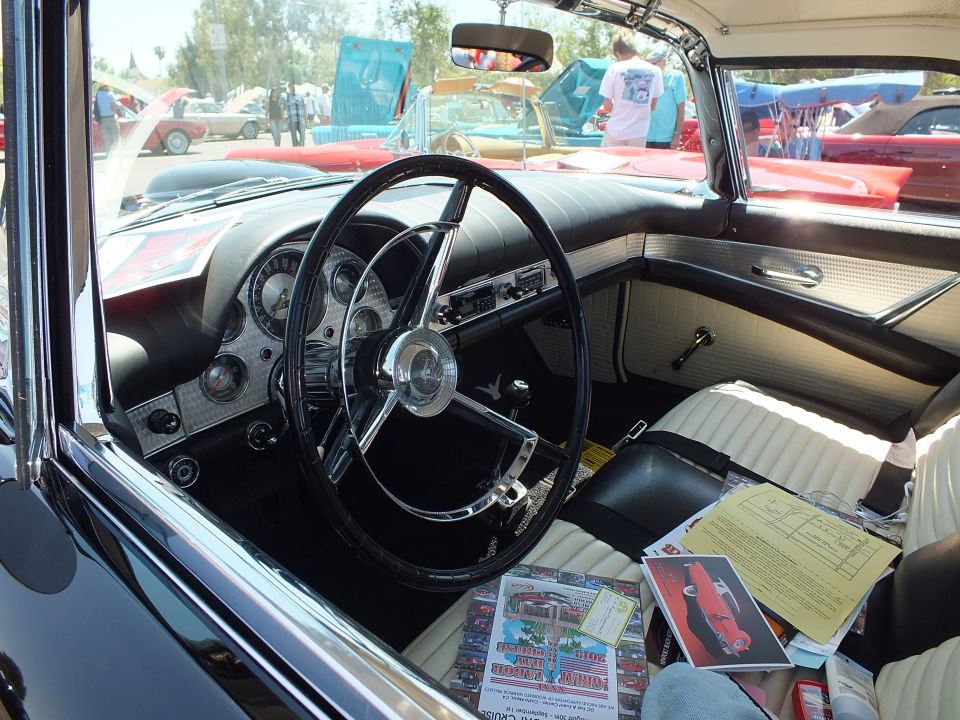 Interior of classic Ford Thunderbird with steering wheel and white seats