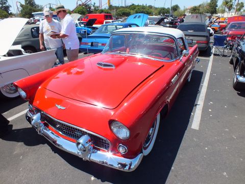 Red Ford Thunderbird with white top and hood scoop at car show