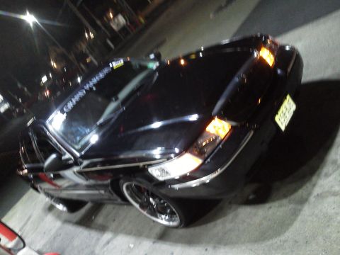 2000 Mercury Grand Marquis - A black Mercury Grand Marquis is shown from a three-quarter front angle at night.