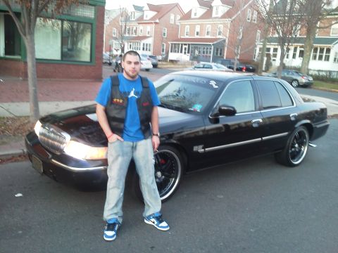 2000 Mercury Grand Marquis - A man poses with his black sedan, which appears to be a 2000 Mercury Grand Marquis.