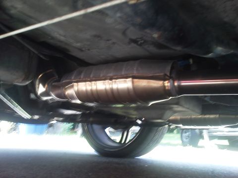 2000 Mercury Grand Marquis - A low-angle view of a vehicle's exhaust system, showing the catalytic converter and part of the muffler.