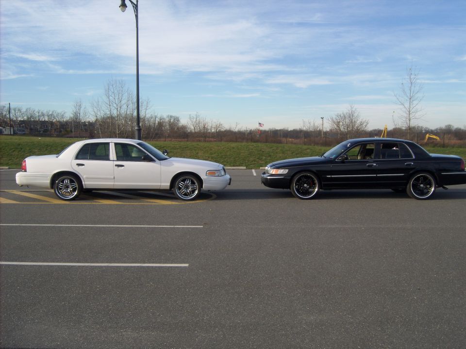 Two sedans, one white and one black, parked side-by-side in a parking lot