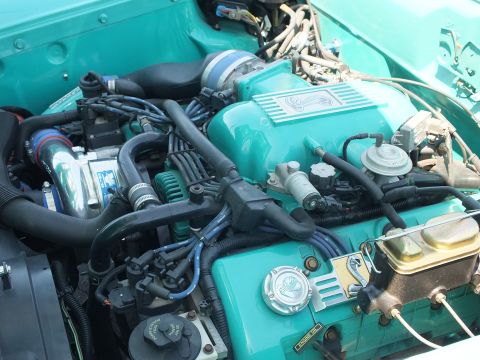 Close-up of turquoise custom engine with supercharger and brake master