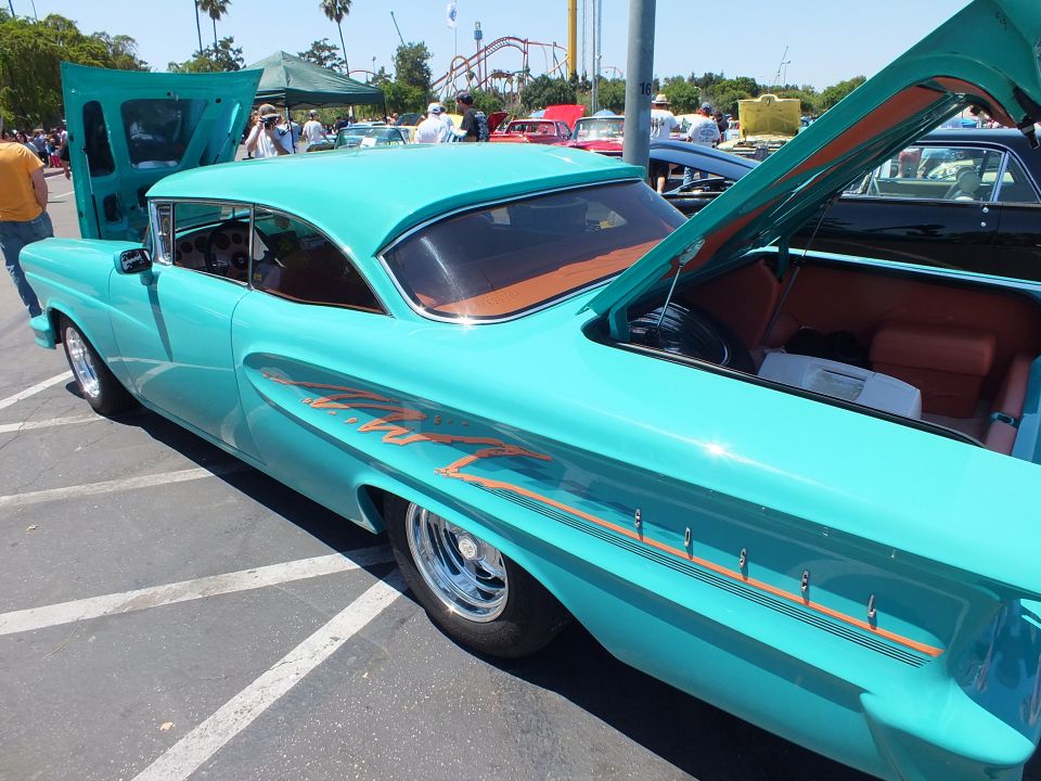 Turquoise custom coupe side view with flame graphics and orange interior