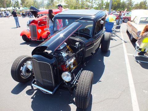 Black 1932-era Ford highboy hot rod with chrome engine and big rear tires at car show