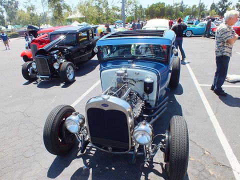 Blue Ford highboy roadster hot rod with Ford badge grille and dual headlights at car show