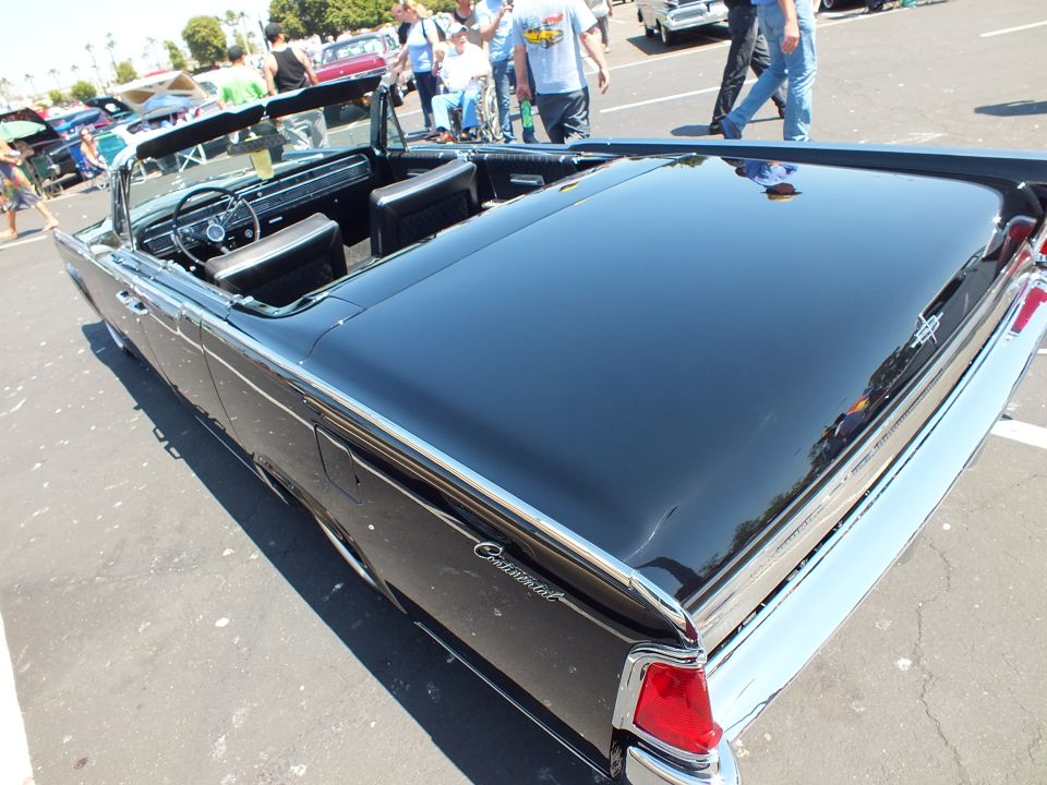 Rear deck of black Lincoln Continental convertible showing trunk badge and taillights