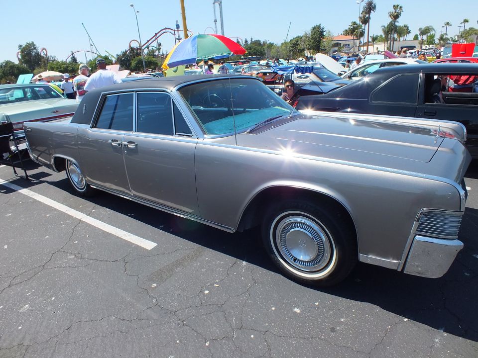Silver 1960s Lincoln Continental sedan with suicide doors at outdoor car show