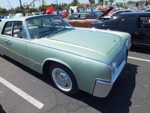 Light green 1960s Lincoln Continental sedan with suicide doors at car show
