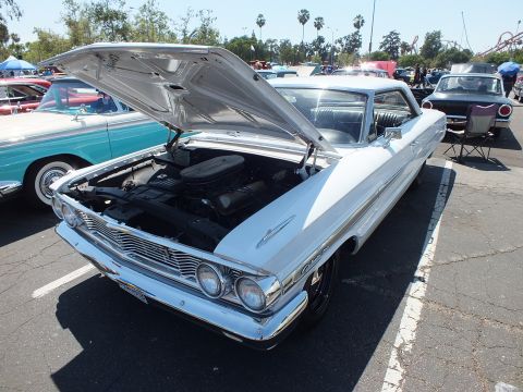 White 1964 Ford Galaxie hardtop with hood up showing V8 engine