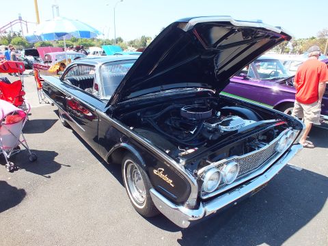 Black 1960 Ford Starliner hardtop with hood up showing V8 engine