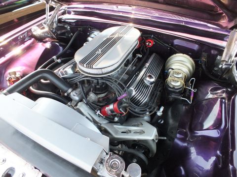 Polished V8 engine with finned air cleaner in purple custom engine bay