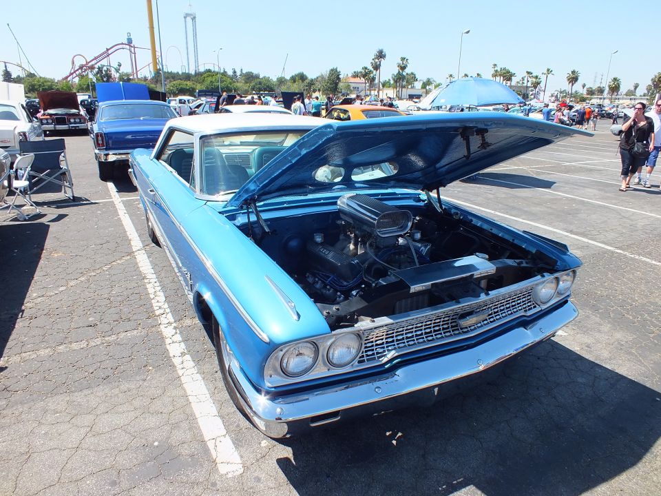 Blue 1963 Ford Galaxie hardtop with white roof and hood up at show