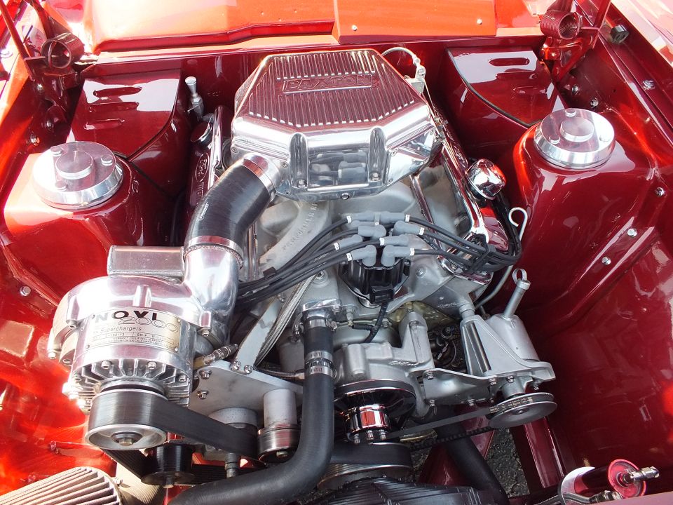 Chromed NOVI supercharged V8 engine in red custom car engine bay