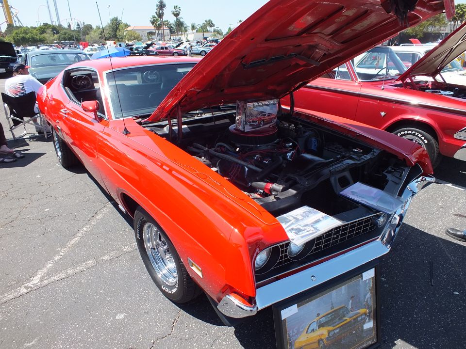 Orange-red Ford Torino fastback with open hood at car show