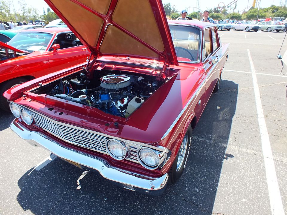 Dark red early-1960s Ford sedan with open hood and chrome grille