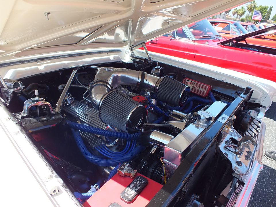 Engine bay with twin cone air filters and blue plug wires under open hood