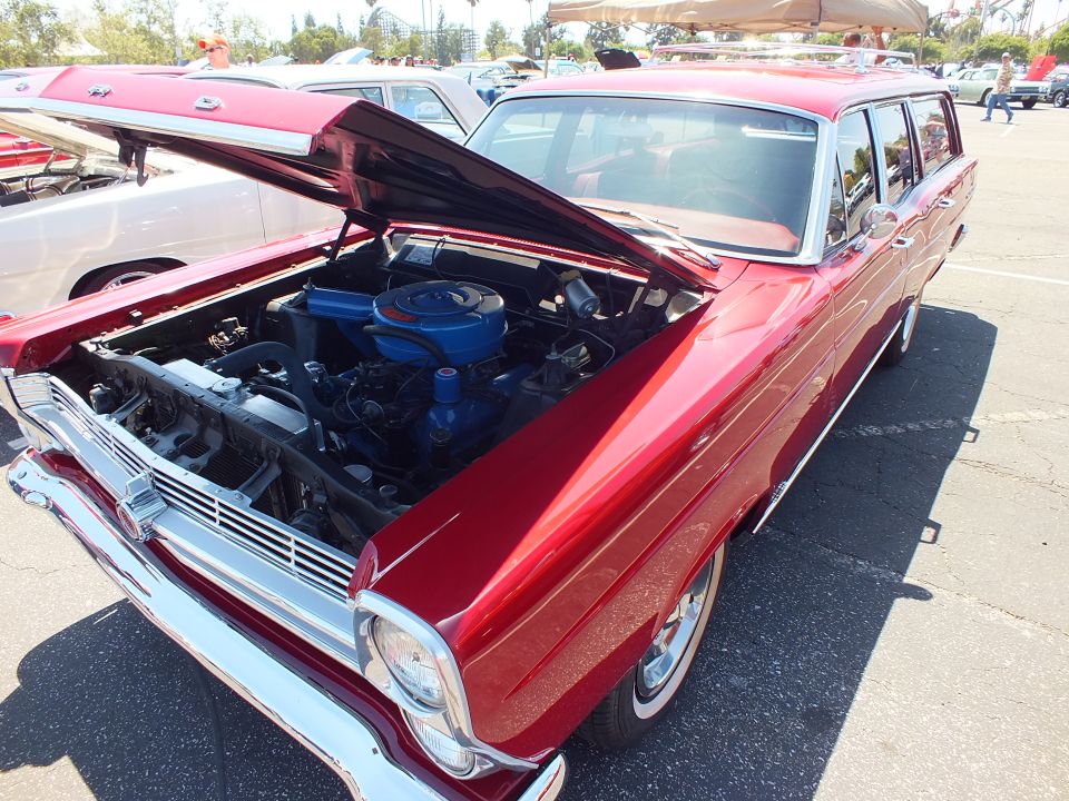 Dark red Ford station wagon with open hood showing blue engine at car show