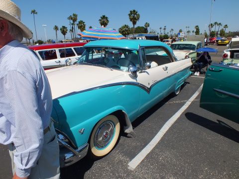 Turquoise and white 1950s hardtop, side view, with whitewall tires and umbrella