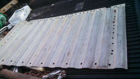 1979 Ford Bronco - A sheet of corrugated metal with numerous holes is placed in the back of a truck.