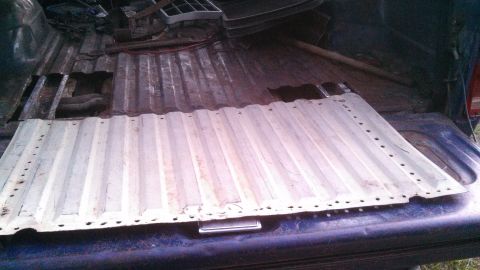 1979 Ford Bronco - The interior of a truck bed is visible, with a metal panel covering part of the floor.