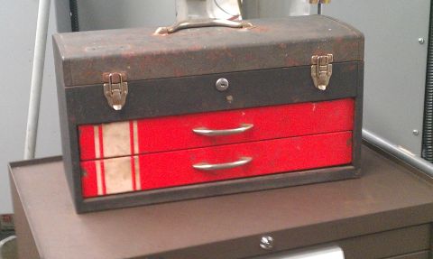 1987 Ford Bronco - A vintage metal toolbox sits on a larger metal cabinet, showing signs of wear.