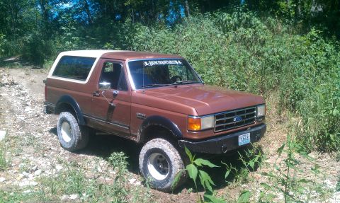 1987 Ford Bronco - This 1987 Ford Bronco is shown off-road with its white top and brown body.