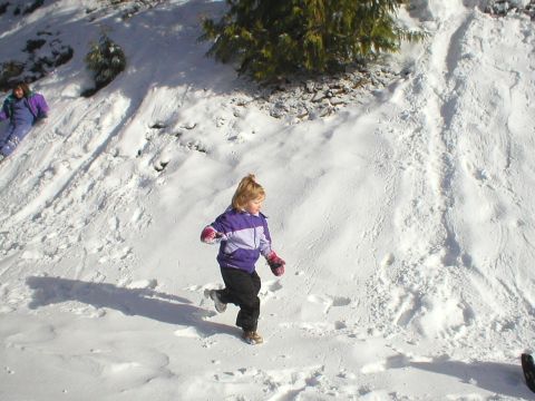 1978 Ford Bronco - Children enjoy a snowy day playing on a hill, with one child running towards the viewer.