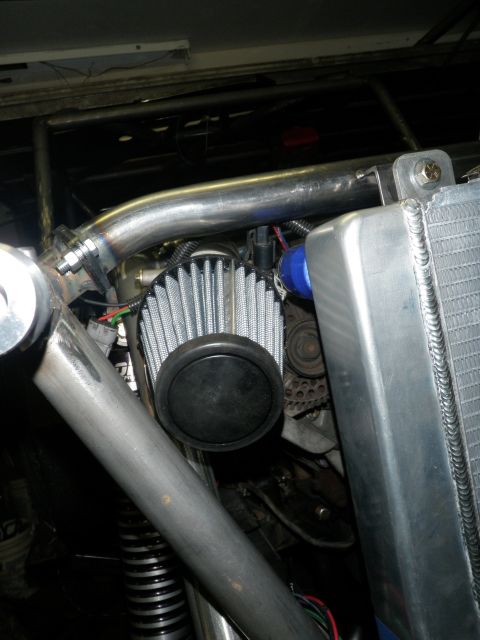1961 International Scout 800 - Close-up view of a custom engine intake system and radiator in a vehicle.