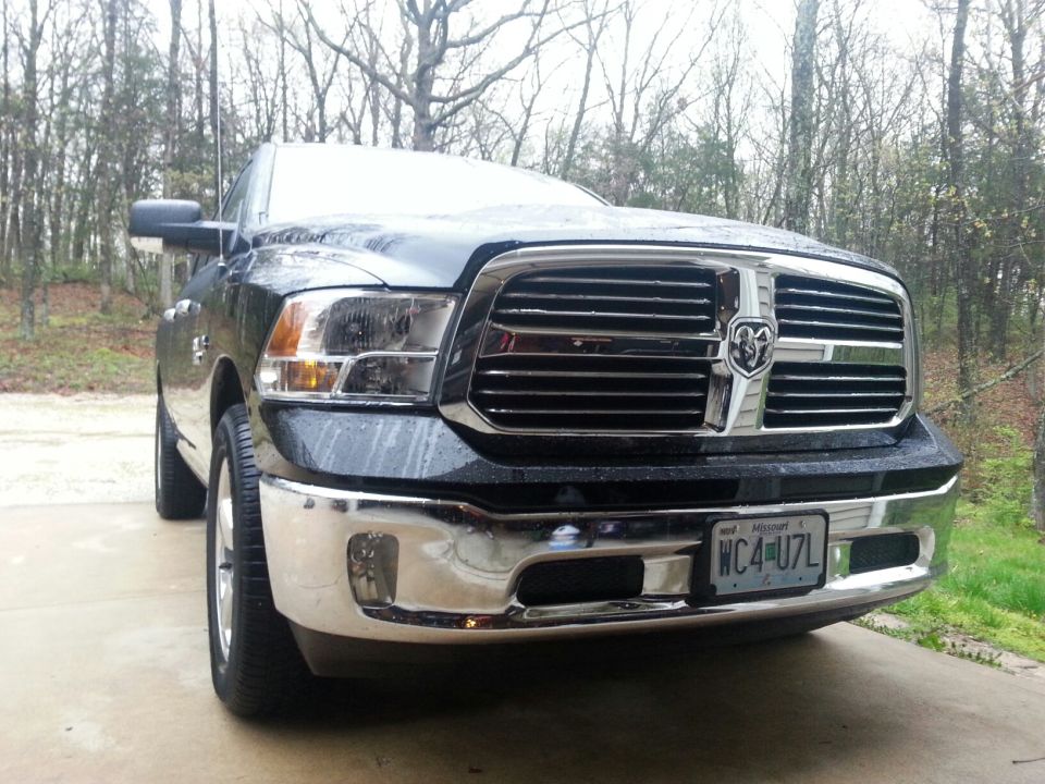 Front view of a black Ram 1500 pickup truck with chrome grille and bumper. License plate reads WC4-U7L