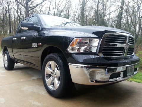 2007 Dodge Durango - A black Ram 1500 pickup truck is parked on a concrete driveway with trees in the background.