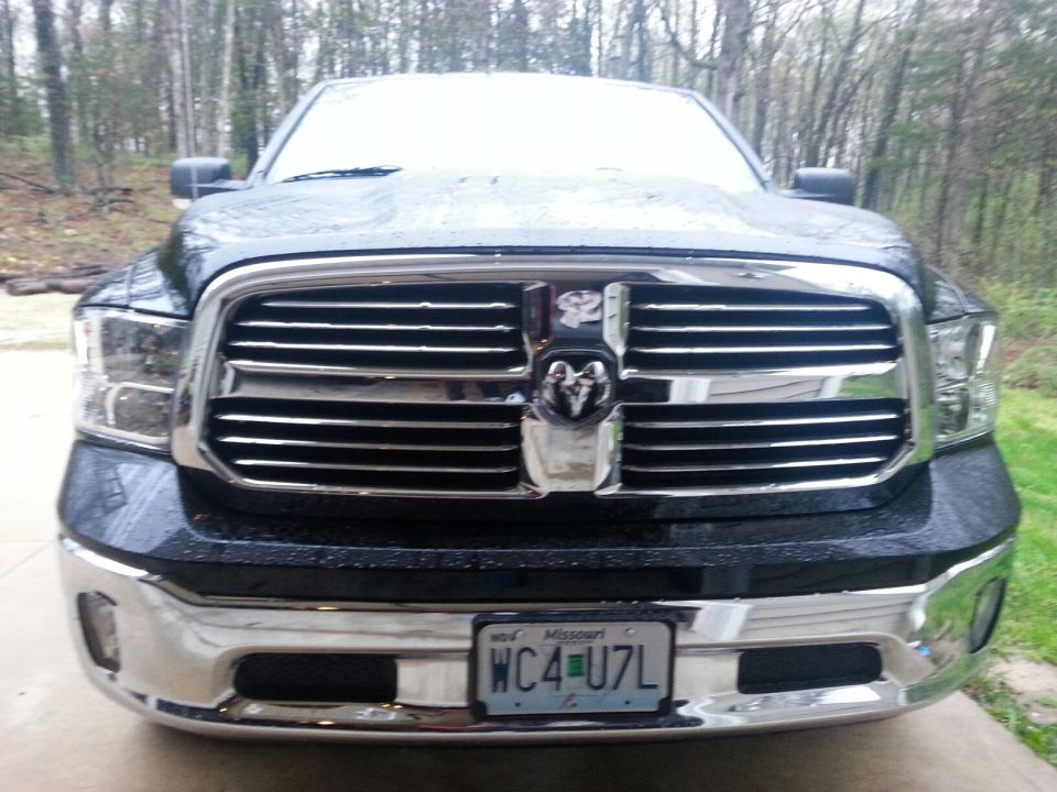 Black Dodge Ram truck front view, chrome grille, license plate WC4-U7L