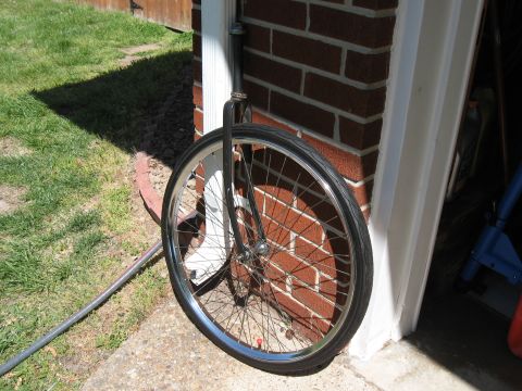 1994 Ford Bronco - A bicycle wheel and fork are seen leaning against a brick wall next to a downspout.