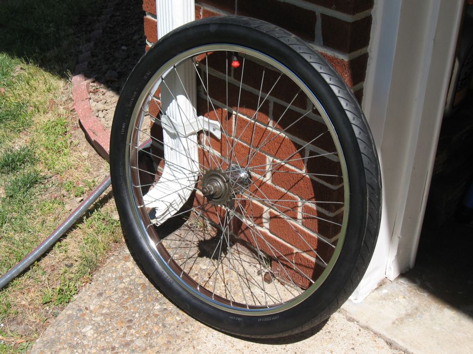 bicycle wheel leaning against a brick wall