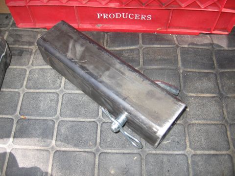 1993 Toyota 4Runner - A metal hitch receiver tube is shown on a textured mat, with a red crate in the background.
