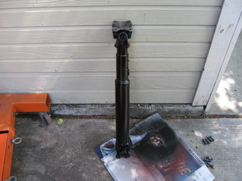 1993 Toyota 4Runner - A black driveshaft rests on a piece of paper against a beige wall, with an orange engine hoist nearby.