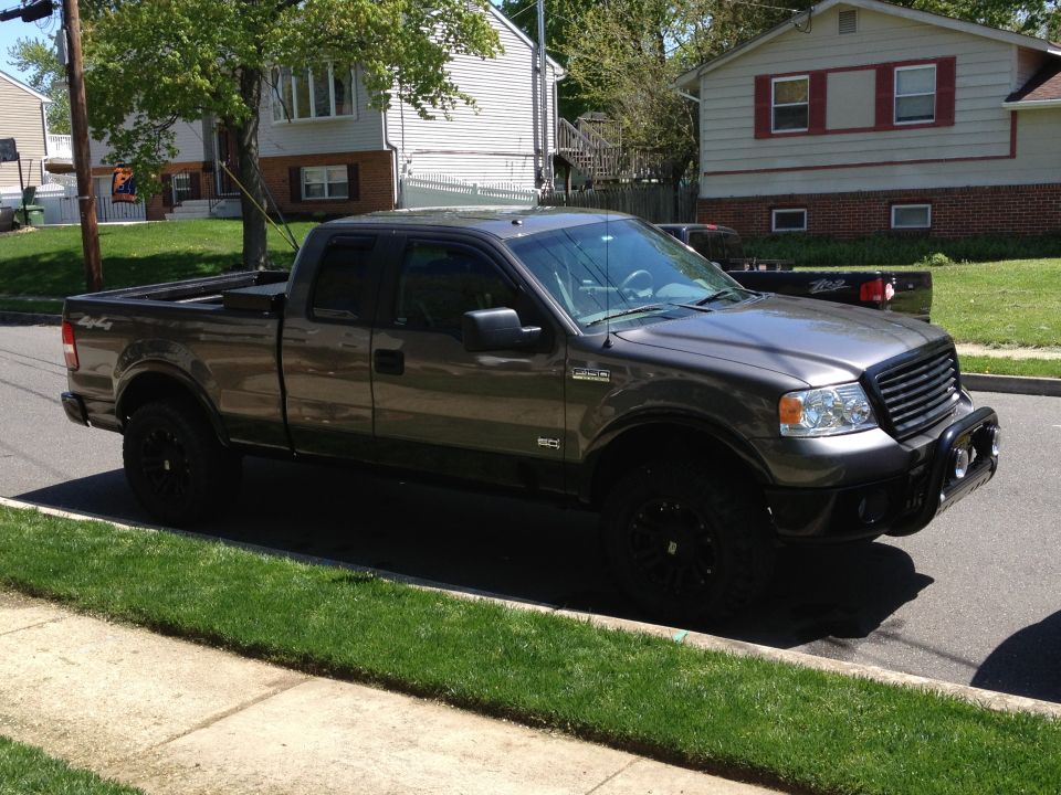Gray Ford F-150 pickup truck parked on street, front quarter view