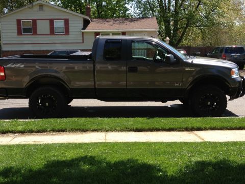 2008 Ford F-150 - Side view of a gray Ford F-150 pickup truck with aftermarket wheels and a bed-mounted toolbox.