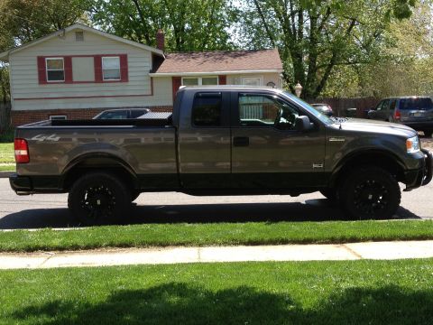 2008 Ford F-150 - This gray 2008 Ford F-150 pickup truck is seen from the side parked on a residential street.