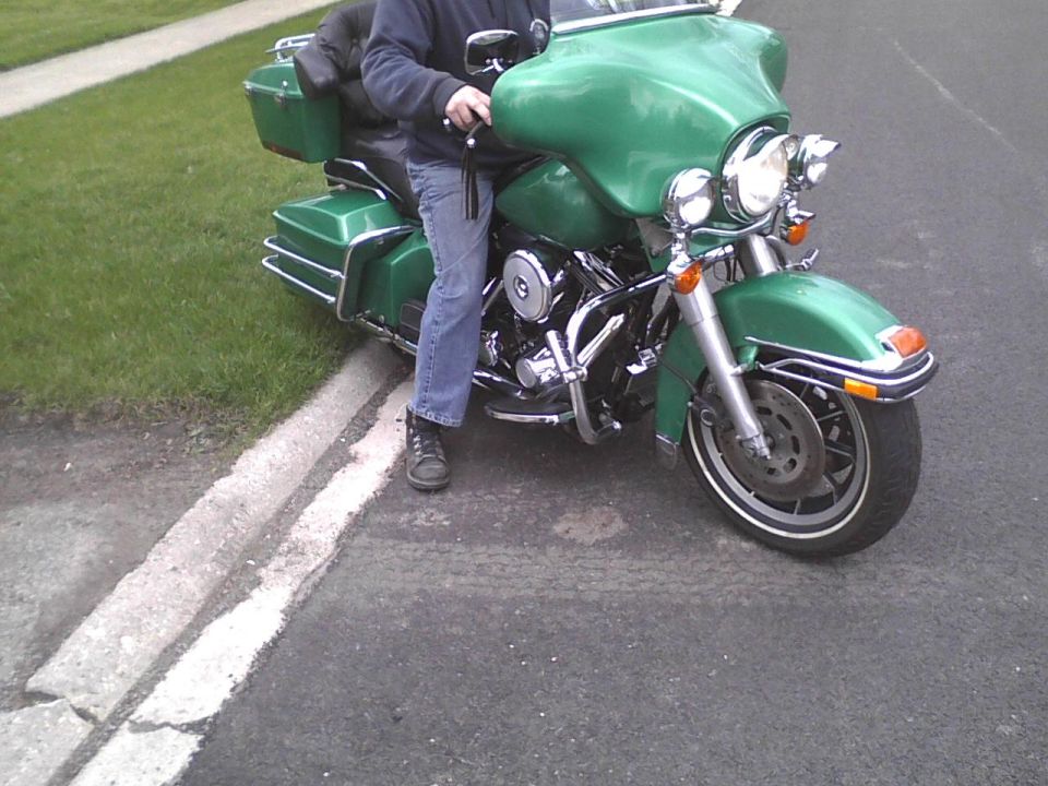 Green motorcycle parked on the side of the road