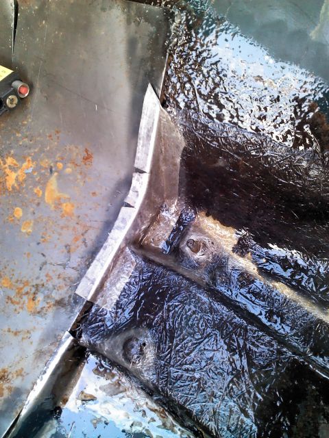 1987 Jeep Comanche - Undercarriage of a vehicle showing rust and protective coating, likely undergoing repair or maintenance.