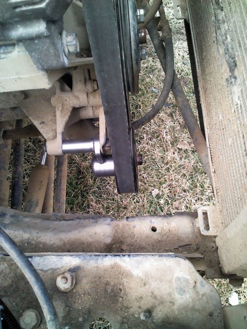 1987 Jeep Comanche - This is a close-up view of the engine's belt tensioner and pulley system, situated near the radiator.