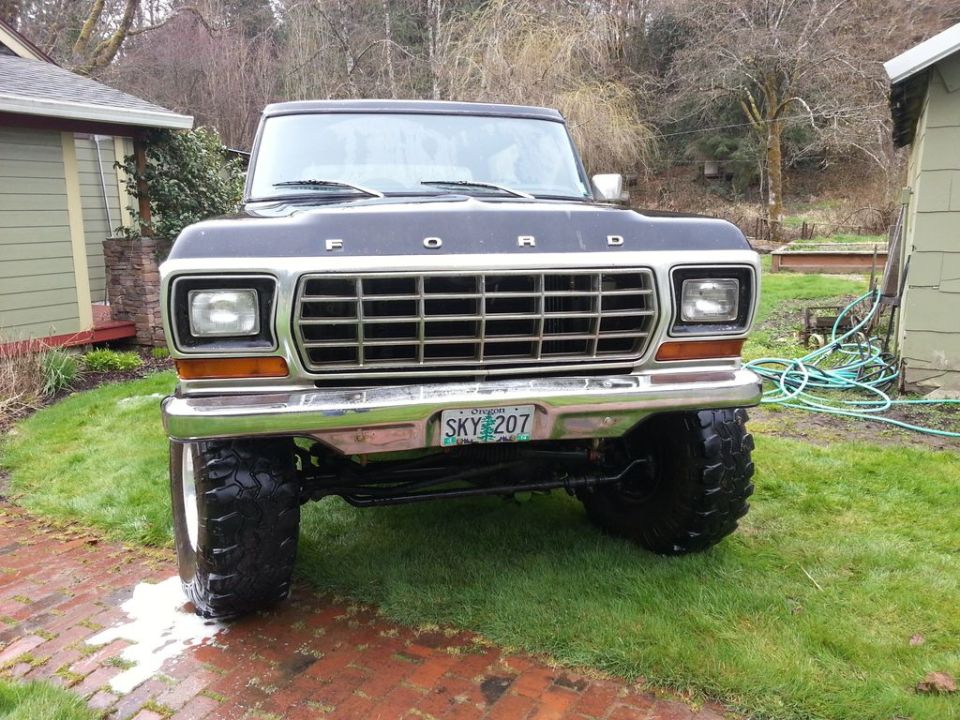 Black 1979 Ford Bronco with lifted suspension and large tires, viewed from the front