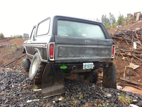1979 Ford Bronco - This black Ford Bronco, likely a 1978 model, is equipped with oversized tires and mud flaps, suggesting off-road use.