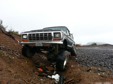 1979 Ford Bronco - This lifted 1979 Ford Bronco navigates a muddy, rocky terrain.